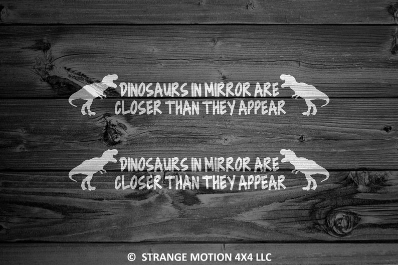 May include: Two white vinyl decals with a dinosaur silhouette and the text "Dinosaurs in mirror are closer than they appear" on a dark wood background.