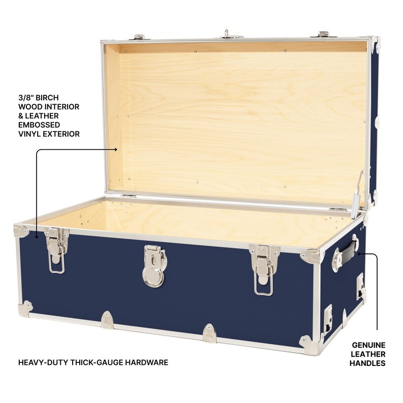 May include: A navy blue trunk with a light wood interior and silver hardware. The trunk features genuine leather handles and embossed vinyl exterior. The text reads: 3/8" birch wood interior & leather embossed vinyl exterior, heavy-duty thick-gauge hardware, and genuine leather handles.