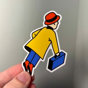 Puede incluir: Un personaje de dibujos animados amarillo y azul con un sombrero rojo y llevando una maleta azul.