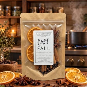 May include: A kraft paper pouch containing a stovetop simmer pot mix with dehydrated orange slices, cinnamon sticks, star anise, and cloves. The label reads PNW BOTANICALS, COZY FALL, STOVETOP SIMMER POT, CINNAMON, CLOVE, STAR ANISE, DEHYDRATED CITRUS.