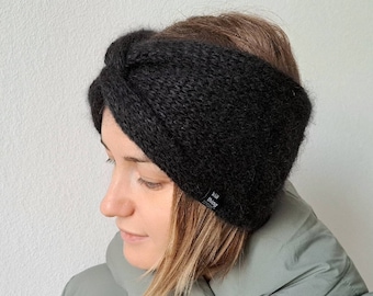 May include: Black knit headband with a twist design. The headband is made of a soft, fuzzy material.