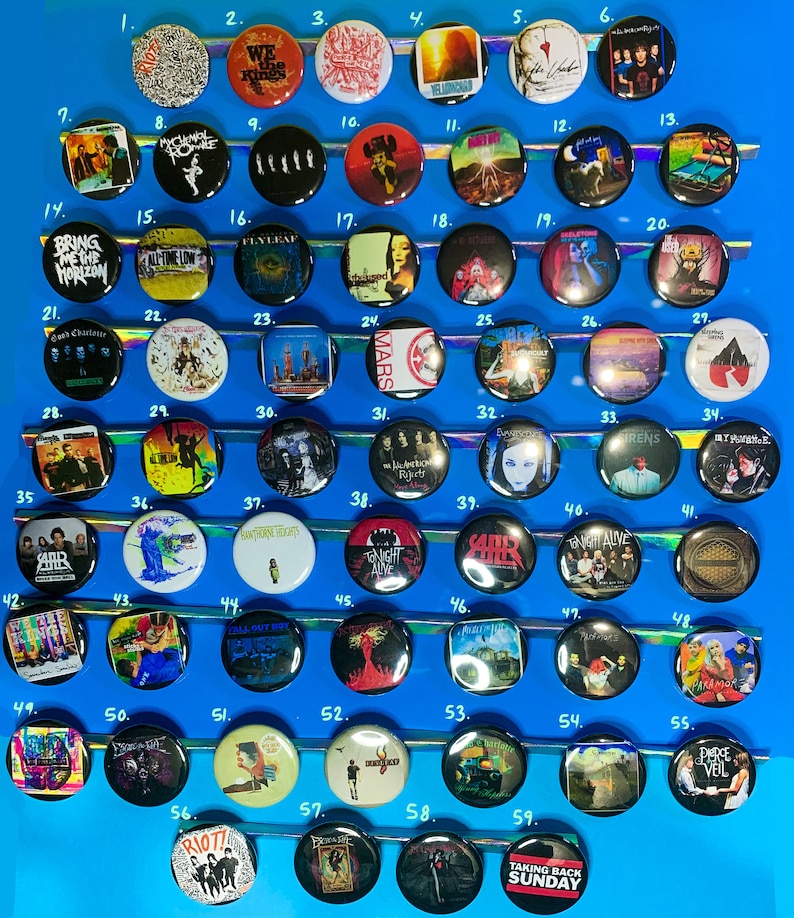 Puede incluir: Una colecci&oacute;n de 59 botones redondos con varios logotipos de bandas y portadas de &aacute;lbumes. Los botones est&aacute;n dispuestos en filas sobre una superficie azul. Algunas de las bandas que aparecen son Bring Me The Horizon, All Time Low, Flyleaf y Pierce The Veil.