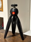 Manfrotto MTPIXI-B PIXI Mini Tripod Black for Photo, Vlog, YouTube & Podcast Video Camera Stand Compact Portable product logo