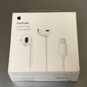 Puede incluir: Auriculares Apple EarPods blancos con conector Lightning en una caja blanca. La caja presenta el logotipo de Apple y las palabras "EarPods Lightning Connector". La imagen muestra los EarPods y el conector Lightning.