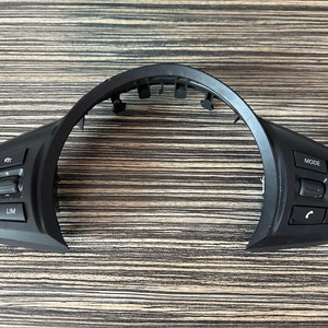 May include: Black plastic steering wheel control buttons with buttons labeled "SET", "LIM", "MODE", "+", "-", and phone icons.