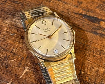 Relógio de pulso clássico Timex Quartz vintage, tom dourado.