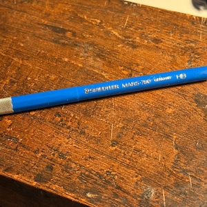 Op de afbeelding: Een blauwe mechanische potlood met een zilveren punt en de tekst "STAEDTLER MARS 780 0.5mm Germany HB" gedrukt op de zijkant.