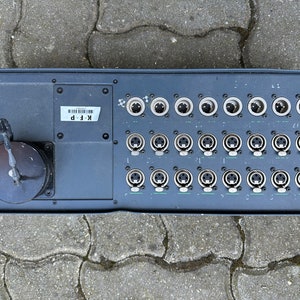 Op de afbeelding: Een zwarte metalen doos met een rij van 36 zilveren connectoren. De doos heeft een label met de tekst "K.F.P."