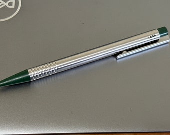 Caneta esferográfica vintage LAMY com logotipo em aço inoxidável escovado e detalhes em verde floresta, fabricada na Alemanha.