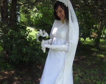 Suknia ślubna z lat 60., ręcznie robiona: koronka w kolorze kości słoniowej, rękawy typu „poet”, podwyższony stan