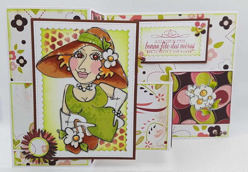 May include: A handmade Mother's Day card featuring a cartoon illustration of a woman in a hat and dress. The card has a scalloped edge and includes the text "Bonne F&ecirc;te des M&egrave;res". Decorative floral patterns and embellishments complete the design.