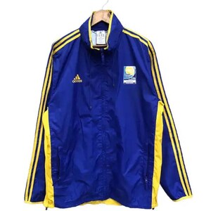 May include: A blue and yellow Adidas windbreaker jacket with a FIFA World Cup logo on the front. The jacket has yellow stripes down the sleeves and a zipper closure.