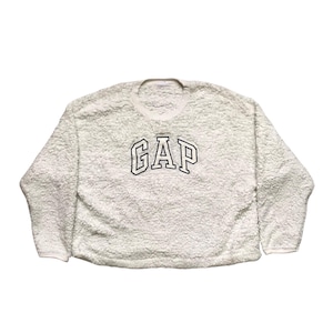 May include: A white fuzzy sweatshirt with a black embroidered "GAP" logo.
