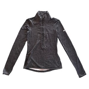 May include: Black long-sleeved athletic top with a white polka dot pattern. The top has a mock neck and a quarter-length zipper. A small white Nike logo is visible on the upper left chest.