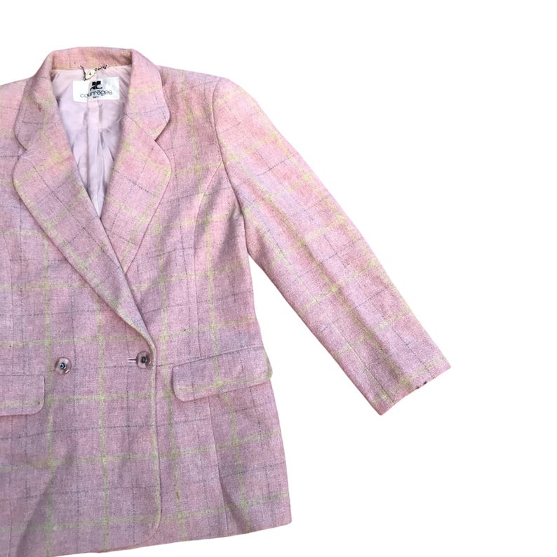 May include: A pink blazer with a plaid pattern. The blazer has a double-breasted closure and two pockets.