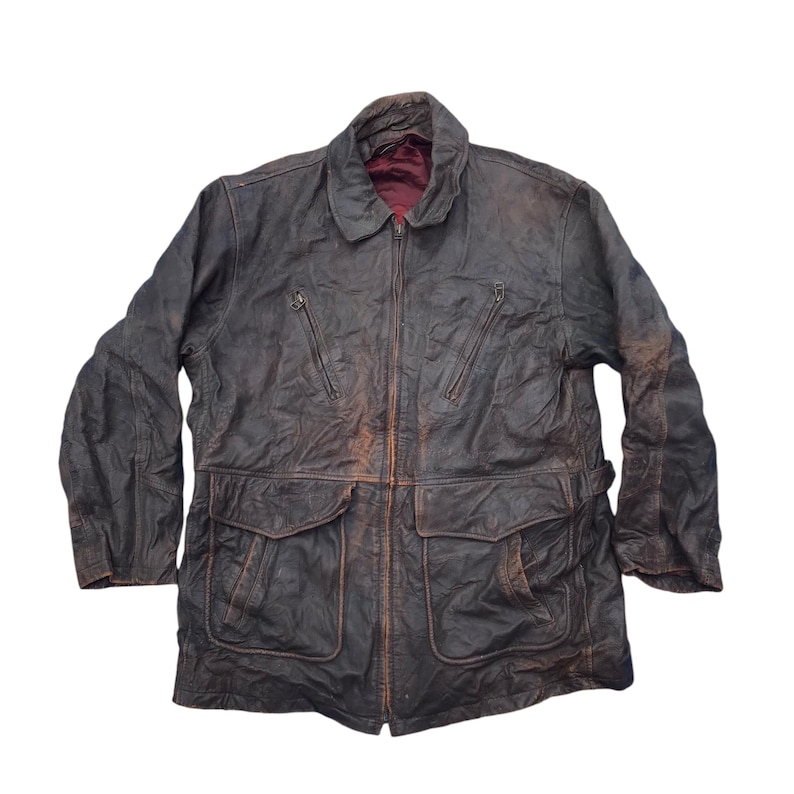 以下が含まれることがあります： ジッパー留めと複数のポケットが付いた茶色の革ジャン。ジャケットは使い古したような風合いになっている。