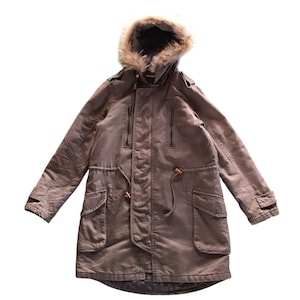 May include: A gray hooded winter parka with a faux fur lined hood. The jacket has a drawstring waist and multiple pockets.