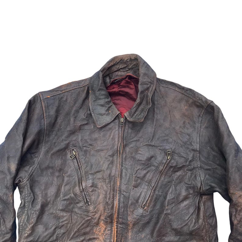 以下が含まれることがあります： 前面にジッパーとポケットが2つ付いた茶色の革ジャン。使い込まれたような風合いがあり、柔らかくしなやかな革で作られています。