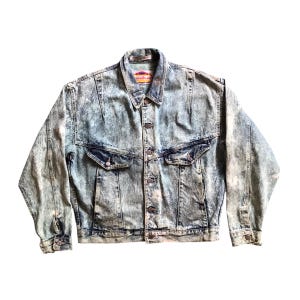 May include: Acid wash denim jacket with button closure, two chest pockets, and two side pockets. The jacket has a classic collar and long sleeves. The brand name is visible on the collar.
