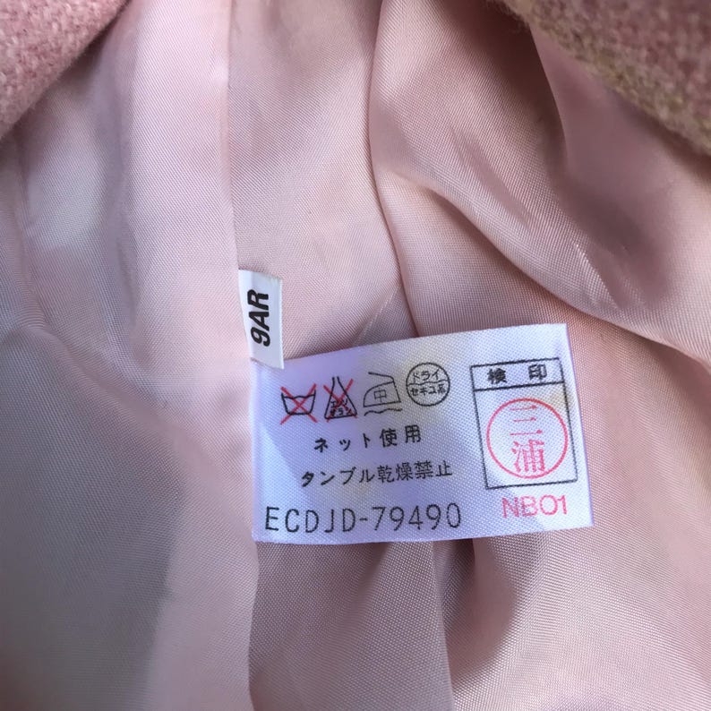 May include: A white tag with washing instructions in Japanese. The tag says "Net use", "Tumble dry prohibited", "Dry clean", and "浦 NB01". The tag also has a number "ECDJD-79490" and a size label that says "9AR".