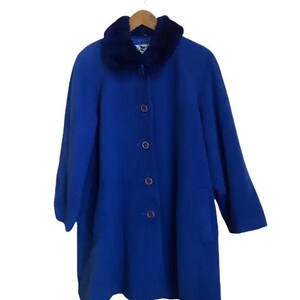 May include: A royal blue coat with a faux fur collar. The coat has a button closure and a pocket on the left side.