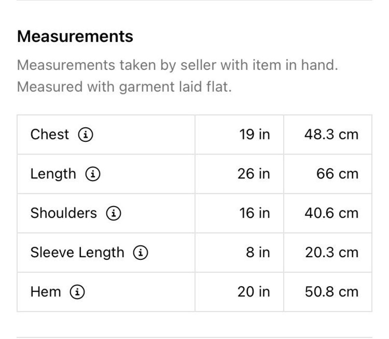 Op de afbeelding: Een tabel met de afmetingen in inches en centimeters voor de borst, lengte, schouders, mouwlengte en zoom.