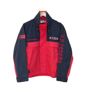 May include: A black and red jacket with a zipper closure and a U.P. Renoma logo on the sleeve. The jacket has a black collar and a red body with black accents.