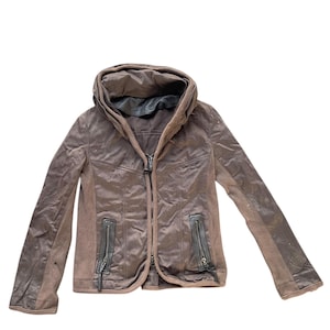 May include: Brown jacket with a high collar and a zipper closure. The jacket has a combination of textures, with ribbed knit sleeves and a quilted front. Two zippered pockets are visible on the front.