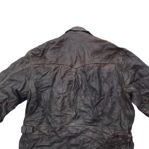 以下が含まれることがあります： ボタン留めとウエストにベルトが付いた茶色の革ジャンパー