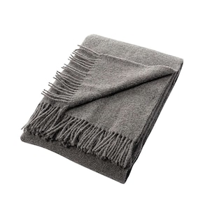 May include: A gray throw blanket with a fringed edge. The blanket is folded in half and the fringe is visible on both sides.
