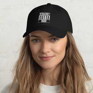 May include: A black baseball cap with a white graphic that says "STRAIGHT OUTTA NAGO" in a blocky font.