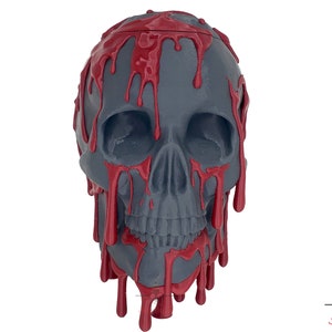 May include: A gray skull with red dripping paint, a Halloween decoration.