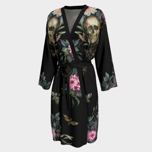 May include: Black silk robe with a floral and skull print. The robe has a wrap style and a tie belt. The print features pink and white flowers, green leaves, and two white skulls.