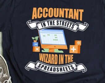 Puede incluir: Una camiseta azul marino con un diseño gráfico que dice "Contable en las calles Mago en las hojas de cálculo". El gráfico incluye un monitor de computadora con una hoja de cálculo, una planta y símbolos matemáticos.