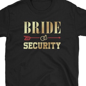 May include: Black t-shirt with gold text that reads "Bride Security" with a red arrow and two gold rings above the text.