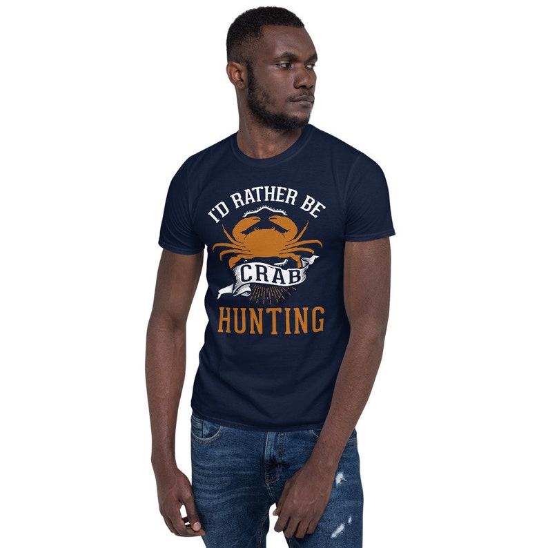 May include: A navy blue t-shirt with the text "I'd rather be crab hunting" in white and orange. A cartoon crab is featured in the design.