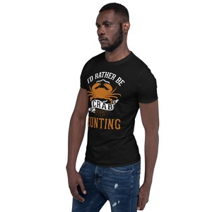 May include: A black t-shirt with a white graphic that says "I'd rather be crab hunting". The graphic features a cartoon crab with an orange shell and white claws.