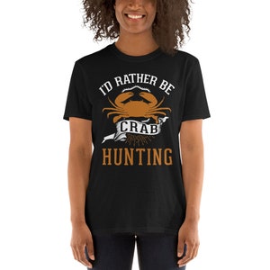 May include: Black t-shirt with a white graphic that says "I'd rather be crab hunting". The graphic features a cartoon crab with a banner that says "crab".