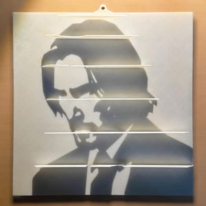 May include: A white silhouette of a person with dark hair, wearing a suit jacket, is shown against a white background. The silhouette is partially obscured by horizontal white lines.