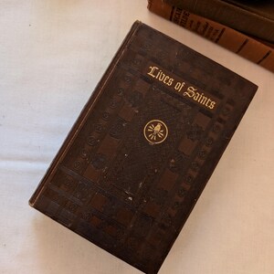Livre religieux ancien - Vies des saints (1954) - Reliure cartonnée en cuir gaufré - Iconographie catholique