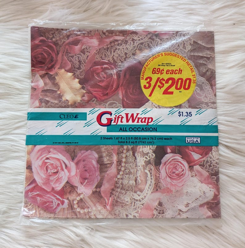K&ouml;nnte beinhalten: Eine Packung Cleo Geschenkpapier, F&uuml;r Alle Anl&auml;sse, mit einem Blumendesign mit rosa und roten Rosen. Die Packung enth&auml;lt zwei Bogen Geschenkpapier, jeweils 1,67 x 2,5 Fu&szlig; (50,8 cm x 76,2 cm) gro&szlig;. Die Gesamtfl&auml;che betr&auml;gt 8,3 Quadratfu&szlig; (7742 cm&sup2;). Der empfohlene Verkaufspreis betr&auml;gt 1,35 &euro;.