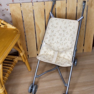 Silla de paseo de caña para muñeca en doble gasa con estampado de ramas forrada de imitación