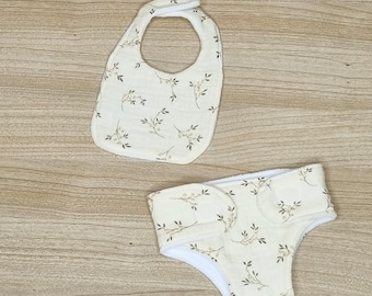 Pañal, babero y toallitas para muñeca de doble gasa con estampado de ramas, disponible en varias tallas.