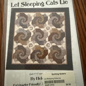 May include: A quilting pattern titled Let Sleeping Cats Lie by StoryQuilts.com, featuring a square quilt design with repeating spiral cat motifs in shades of brown, tan, and grey. The pattern includes a 57.5 inch square finished quilt size.