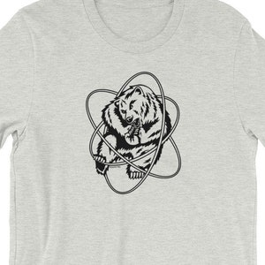 Op de afbeelding: Een grijs T-shirt met een zwart-witte afbeelding van een beer in een atoomsymbool.
