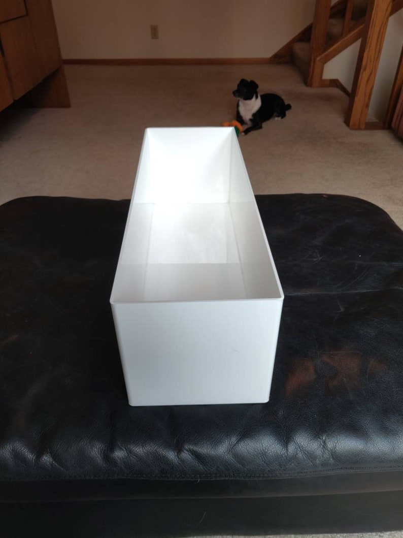 May include: A white rectangular planter with a smooth surface
