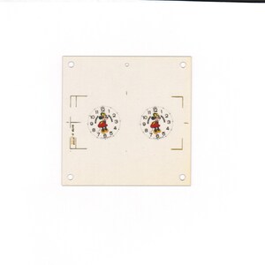 May include: A cream-colored card featuring two Mickey Mouse clock faces. Each clock face has a white background with black numbers and hands, and a red and yellow Mickey Mouse figure in the center. The card has four small holes in the corners.