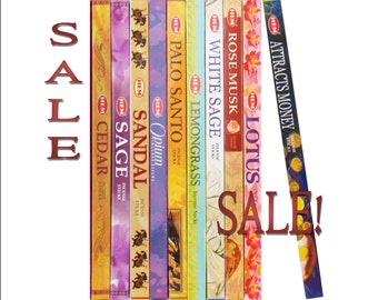 May include: A variety pack of HEM incense sticks in various scents, including Cedar, Sage, Sandal, Opium, Palo Santo, Lemongrass, White Sage, Rose Musk, Lotus, and Attracts Money. The sticks are arranged vertically in a row, with the brand name HEM visible on each box. The text "SALE!" is written in red letters across the image.