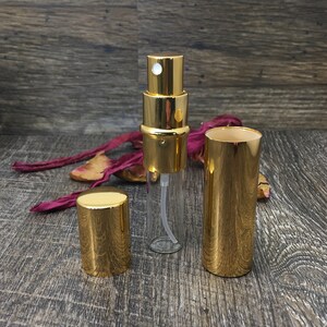 All gold perfume travel bottle with the outer casing off so you can see the 12 ml clear roll on bottle inside. This allows you to refill your bottle repeatedly! This is a great refillable perfume bottle!