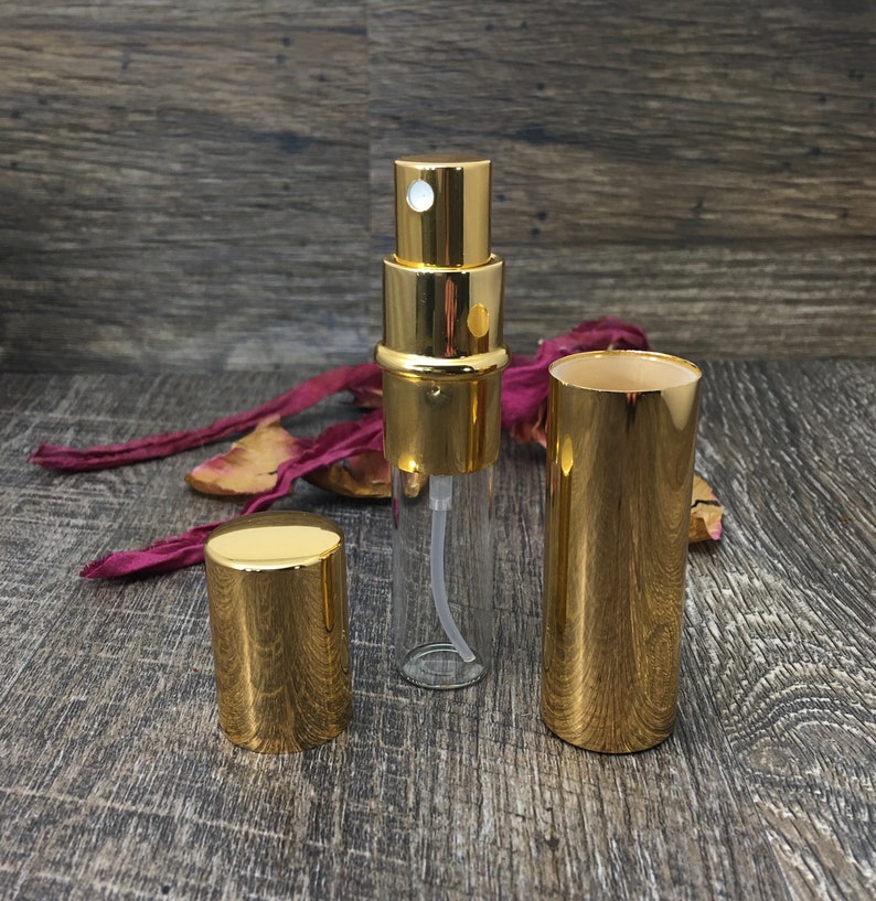 All gold perfume travel bottle with the outer casing off so you can see the 12 ml clear roll on bottle inside. This allows you to refill your bottle repeatedly! This is a great refillable perfume bottle!